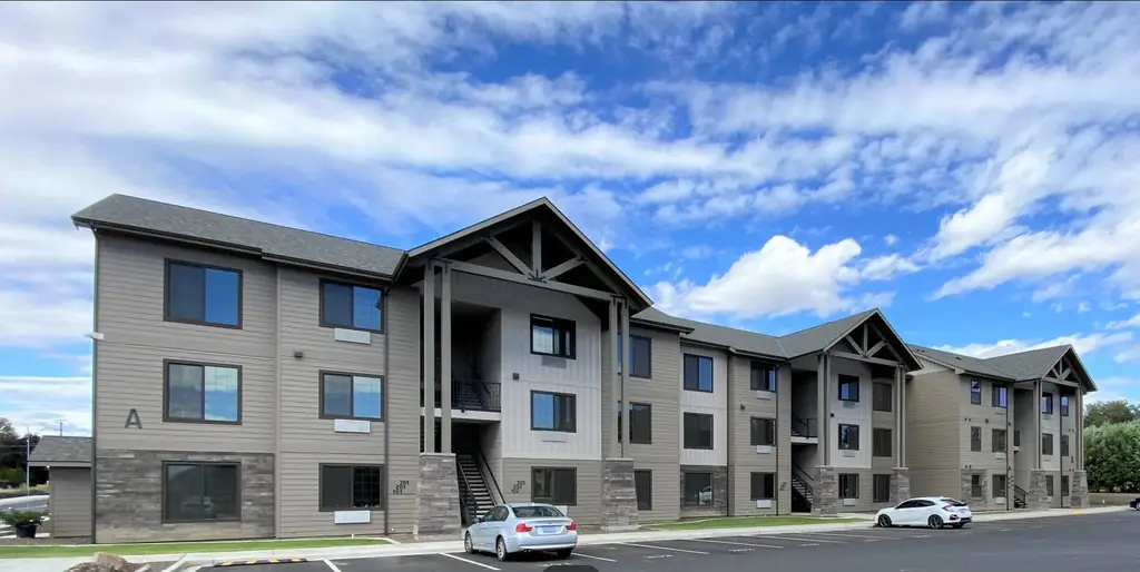 Borton Apartments in Yakima, finished: tan and grey lap siding, white gables, stone base