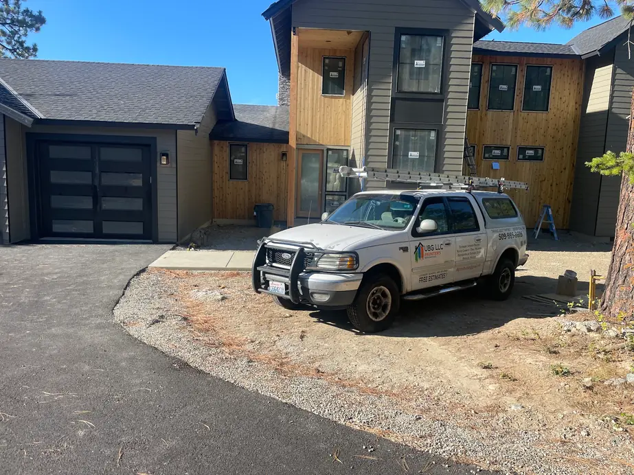 A UBG pickup with the logo on the door in front of a cedar and grey modern home